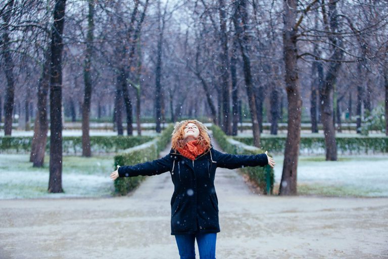 Red hair woman getting wet under the snow